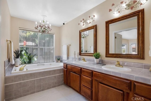 bathroom with tile patterned floors, vanity, a relaxing tiled tub, and a chandelier