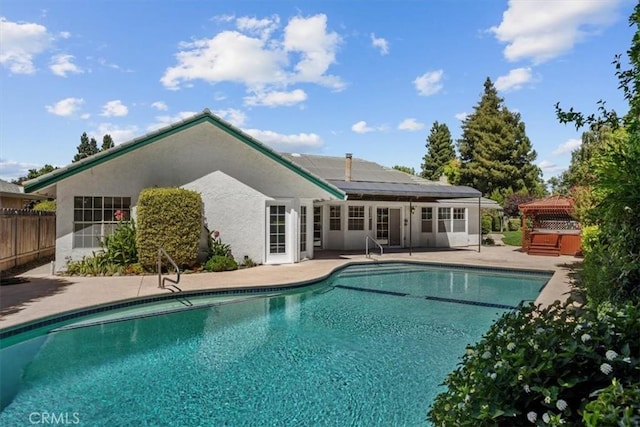 view of pool featuring fence, a fenced in pool, a patio area, and a hot tub