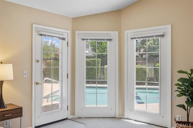doorway to outside with carpet flooring and plenty of natural light