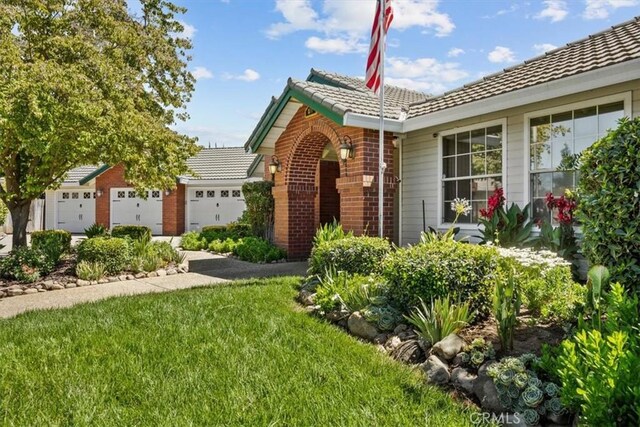 ranch-style home with a garage and a front lawn