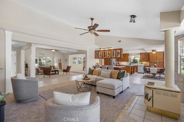 tiled living room featuring ceiling fan and high vaulted ceiling