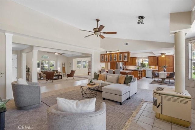 living room with decorative columns, a ceiling fan, light tile patterned floors, and lofted ceiling