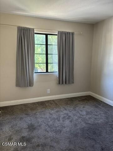 spare room with dark colored carpet