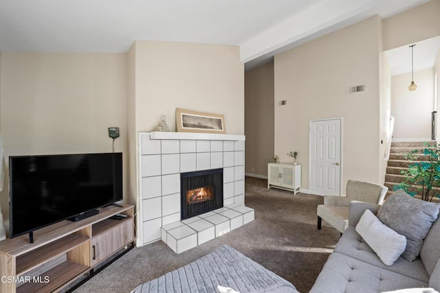 living room with carpet and a tiled fireplace