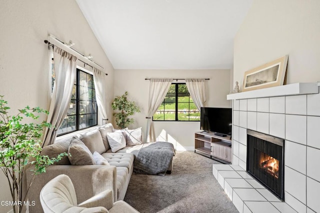 carpeted living room with a fireplace and vaulted ceiling