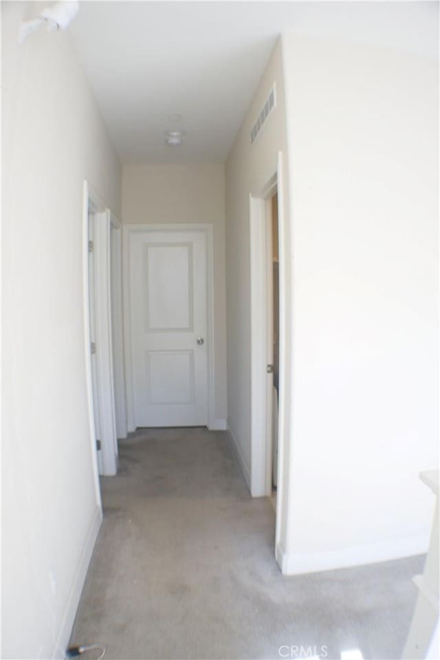 hall with light colored carpet