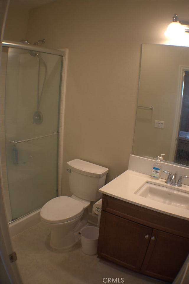 bathroom featuring vanity, toilet, and an enclosed shower