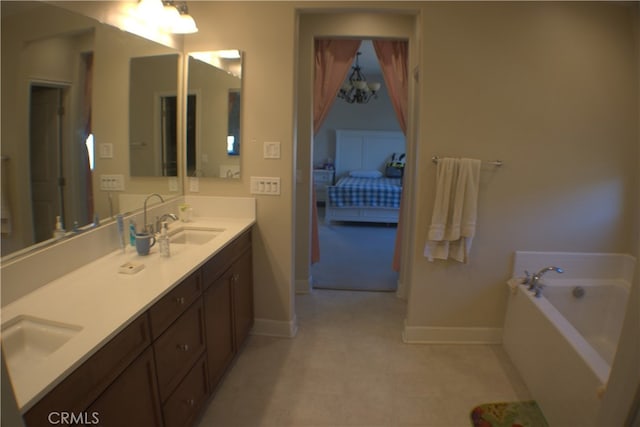 bathroom with vanity, a bath, and an inviting chandelier