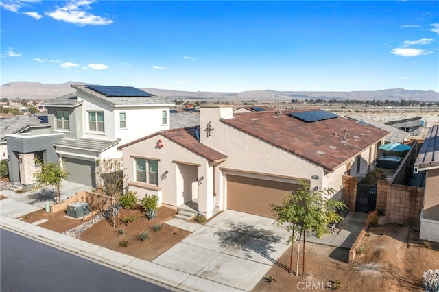 view of front of property featuring a mountain view, solar panels, and central air condition unit