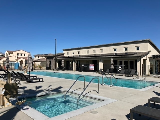 view of swimming pool featuring a community hot tub and a patio area