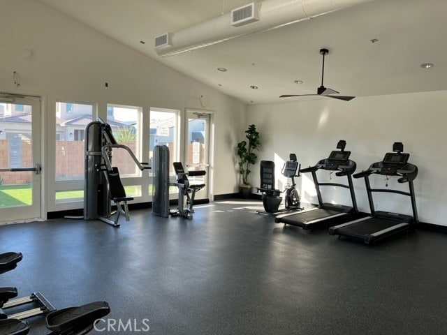 exercise room with ceiling fan and vaulted ceiling