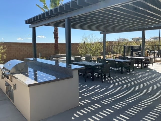 view of patio with an outdoor kitchen, area for grilling, and a bar