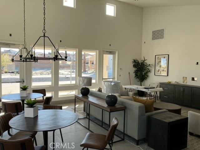 living room featuring a chandelier, a high ceiling, and plenty of natural light