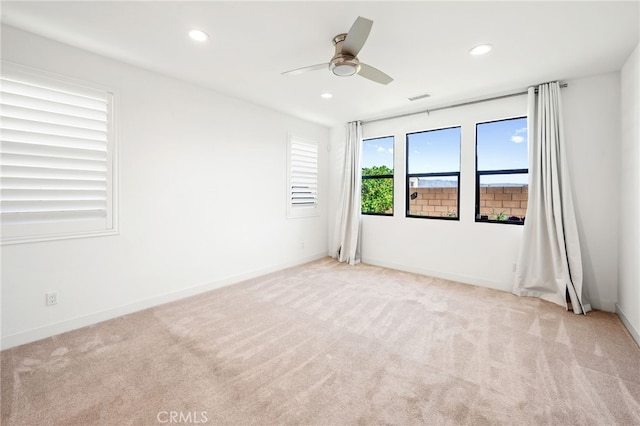 spare room with light colored carpet and ceiling fan