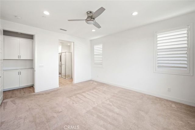 unfurnished bedroom featuring ceiling fan and light carpet