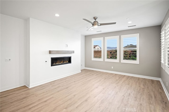 unfurnished living room featuring ceiling fan and light hardwood / wood-style floors