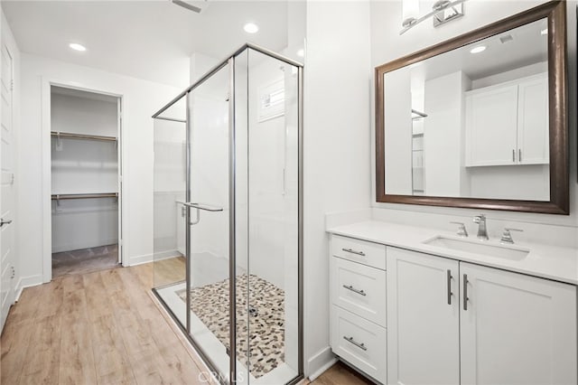 bathroom featuring vanity, wood-type flooring, and walk in shower