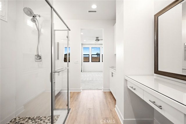 bathroom with a shower with door, vanity, and wood-type flooring