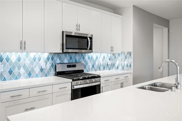 kitchen featuring backsplash, white cabinetry, sink, and stainless steel appliances