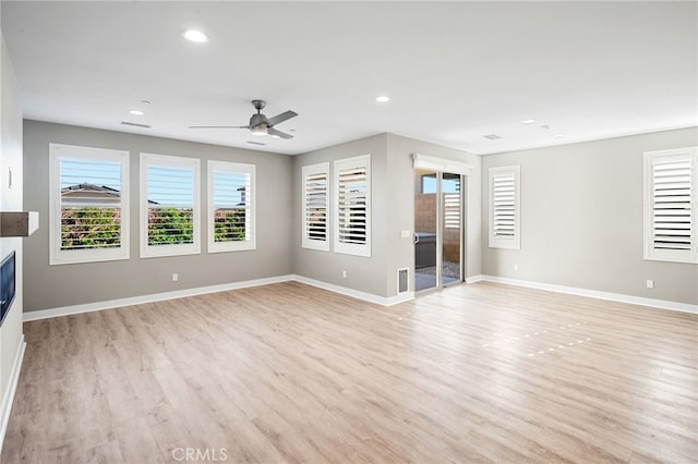 unfurnished living room featuring ceiling fan and light hardwood / wood-style floors