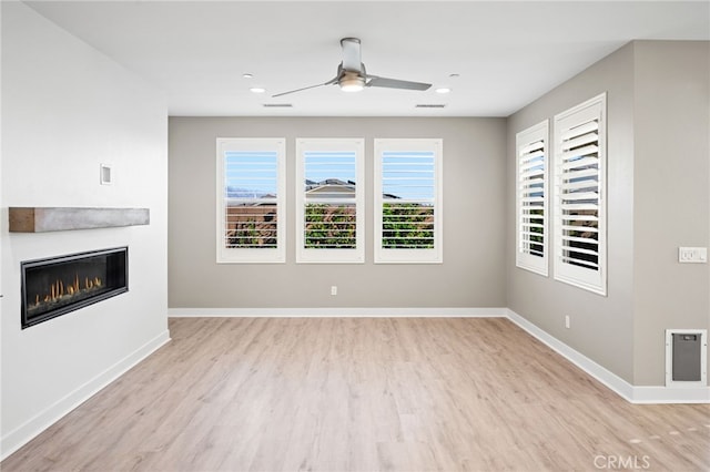 unfurnished living room featuring ceiling fan and light hardwood / wood-style floors