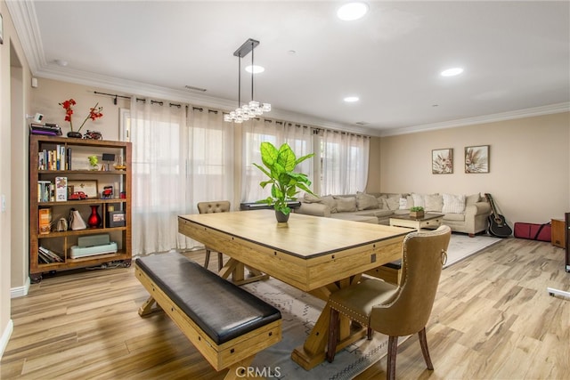 dining room featuring ornamental molding, a chandelier, and light hardwood / wood-style floors