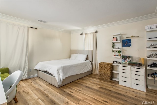 bedroom featuring ornamental molding and light hardwood / wood-style floors