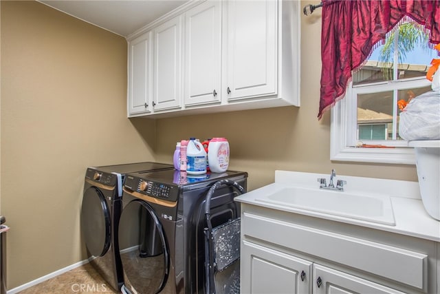 laundry area featuring cabinets, washer and clothes dryer, and sink