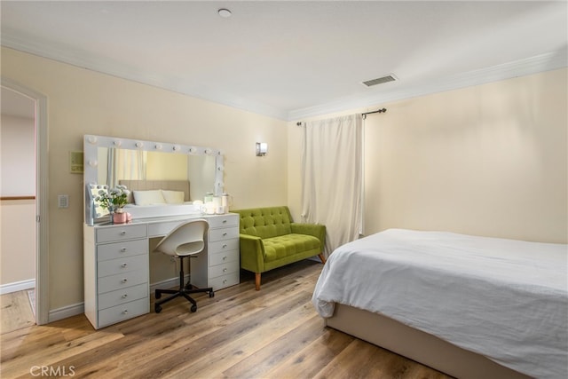 bedroom featuring hardwood / wood-style flooring and crown molding