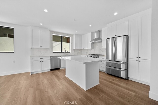 33851 Malaga Dr, Dana Point, CA 92629 - kitchen with stainless steel appliances, wall chimney exhaust hood, a kitchen island, light countertops, and decorative backsplash