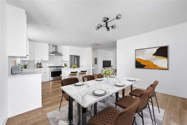 dining space featuring light wood-type flooring and sink