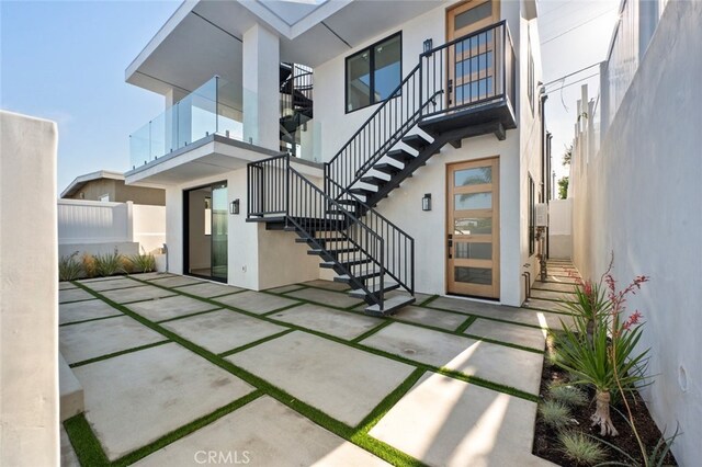 back of property featuring a patio and a balcony