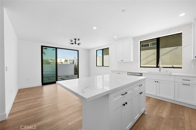 kitchen with a kitchen island, light hardwood / wood-style flooring, and white cabinetry