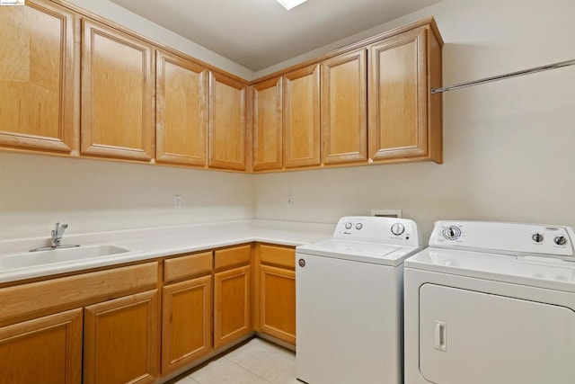 washroom with cabinets, light tile patterned flooring, washing machine and clothes dryer, and sink