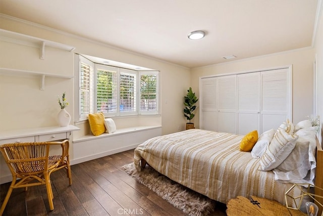 bedroom featuring ornamental molding, dark wood-type flooring, and a closet