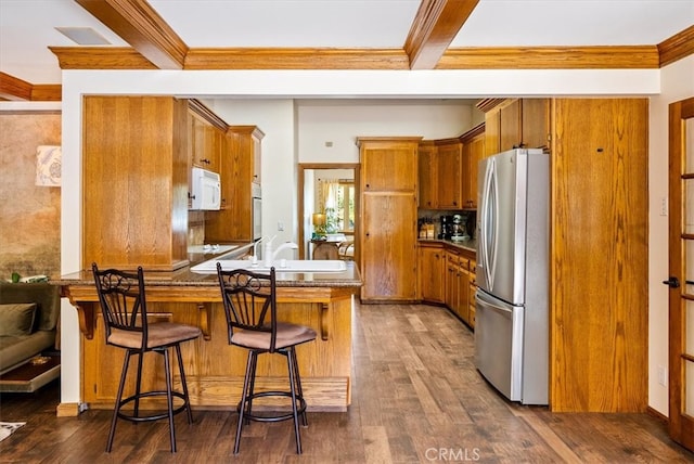 kitchen with dark hardwood / wood-style flooring, kitchen peninsula, and stainless steel refrigerator