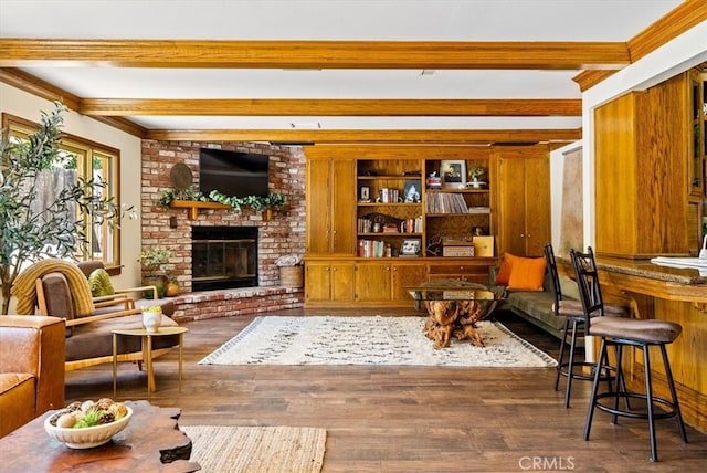 living room featuring wood-type flooring, ornamental molding, and a brick fireplace