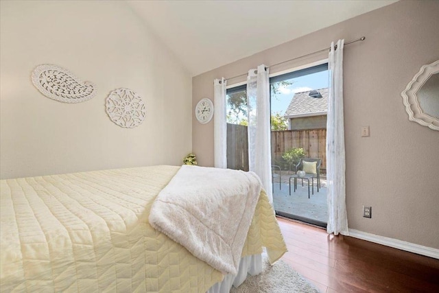 bedroom with hardwood / wood-style flooring, vaulted ceiling, and access to exterior