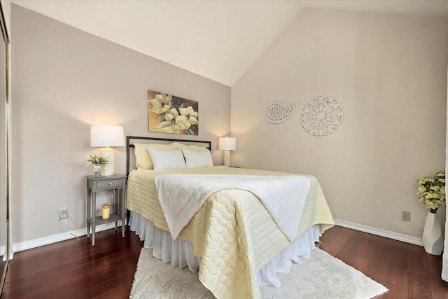 bedroom with vaulted ceiling and dark hardwood / wood-style flooring