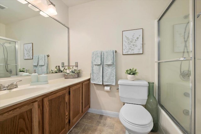 full bathroom featuring vanity, toilet, and shower / bath combination with glass door