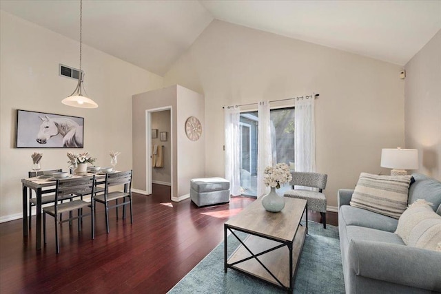 living room featuring dark wood-type flooring and high vaulted ceiling