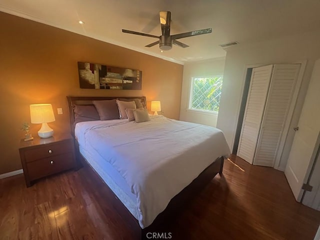 bedroom with dark hardwood / wood-style floors, ceiling fan, and crown molding