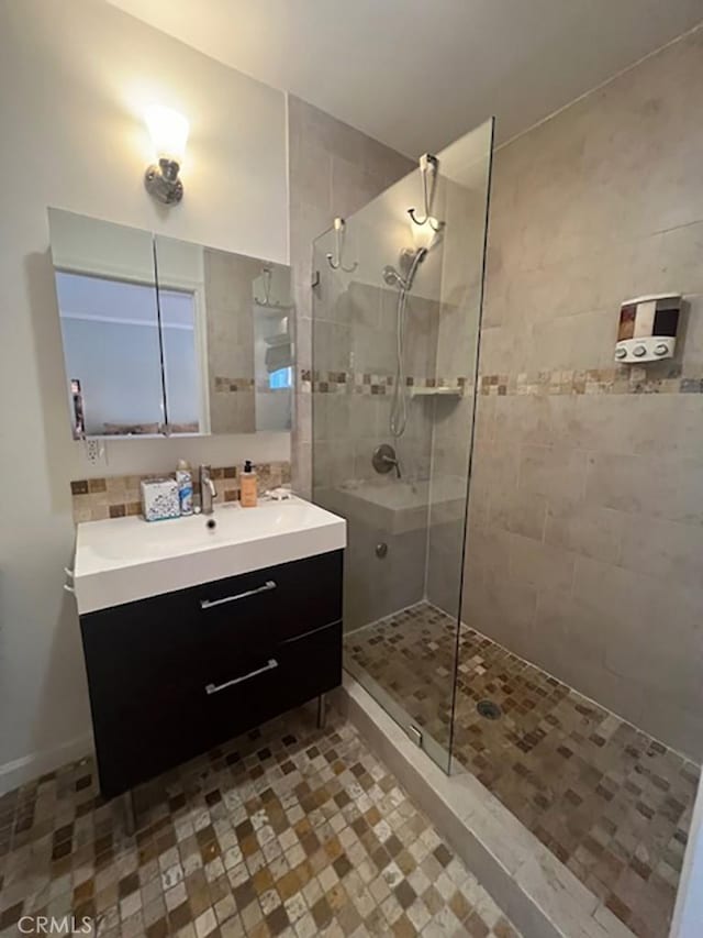 bathroom featuring a tile shower and vanity