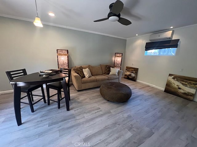 living room featuring ceiling fan, ornamental molding, a wall mounted air conditioner, and hardwood / wood-style flooring