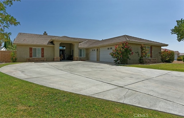 ranch-style house featuring a front lawn and a garage