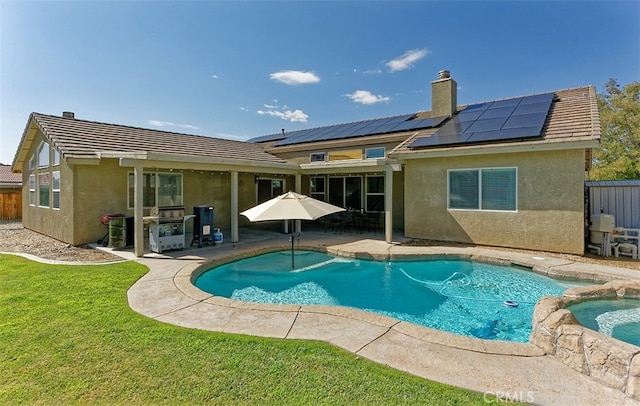 back of property featuring a patio area, solar panels, a pool with hot tub, and a yard