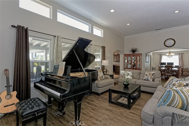 misc room with crown molding, hardwood / wood-style flooring, an inviting chandelier, and a high ceiling