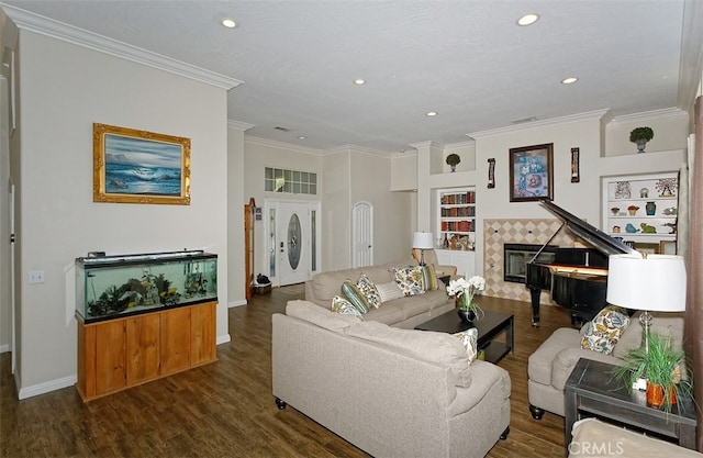 living room featuring crown molding, a textured ceiling, dark wood-type flooring, and a tile fireplace