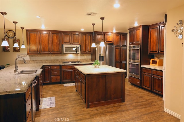 kitchen featuring sink, decorative light fixtures, stainless steel appliances, and dark wood-type flooring