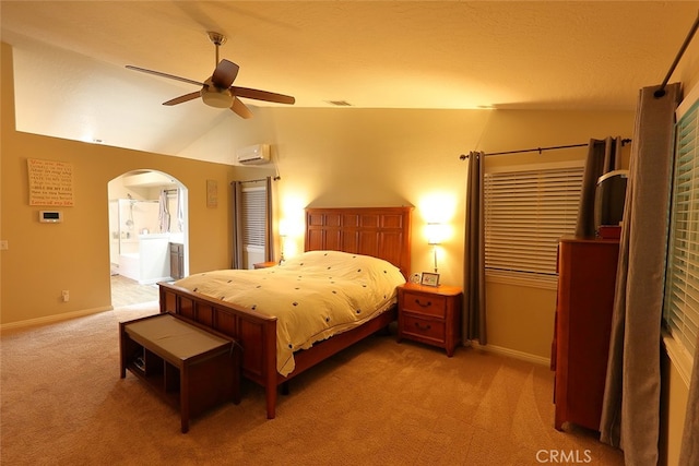 bedroom with ensuite bathroom, carpet floors, ceiling fan, vaulted ceiling, and a wall unit AC